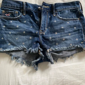 Hollister jeansshorts  - Köpte på vinted är i jätte bra skick förutom att några av stenarna har ramlat av som man ser på bilden men inget man tänker på, skriv om frågor 