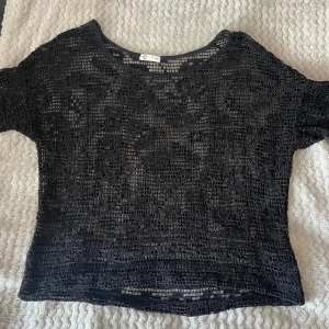 Svart nätmönstrad topp från C - Säljer en svart nätmönstrad topp från Cubus. Toppen är kortärmad och gjord i ett lätt och luftigt material. Tröjan har inga defekter. Kontakta mig om du har fler frågor 😊
