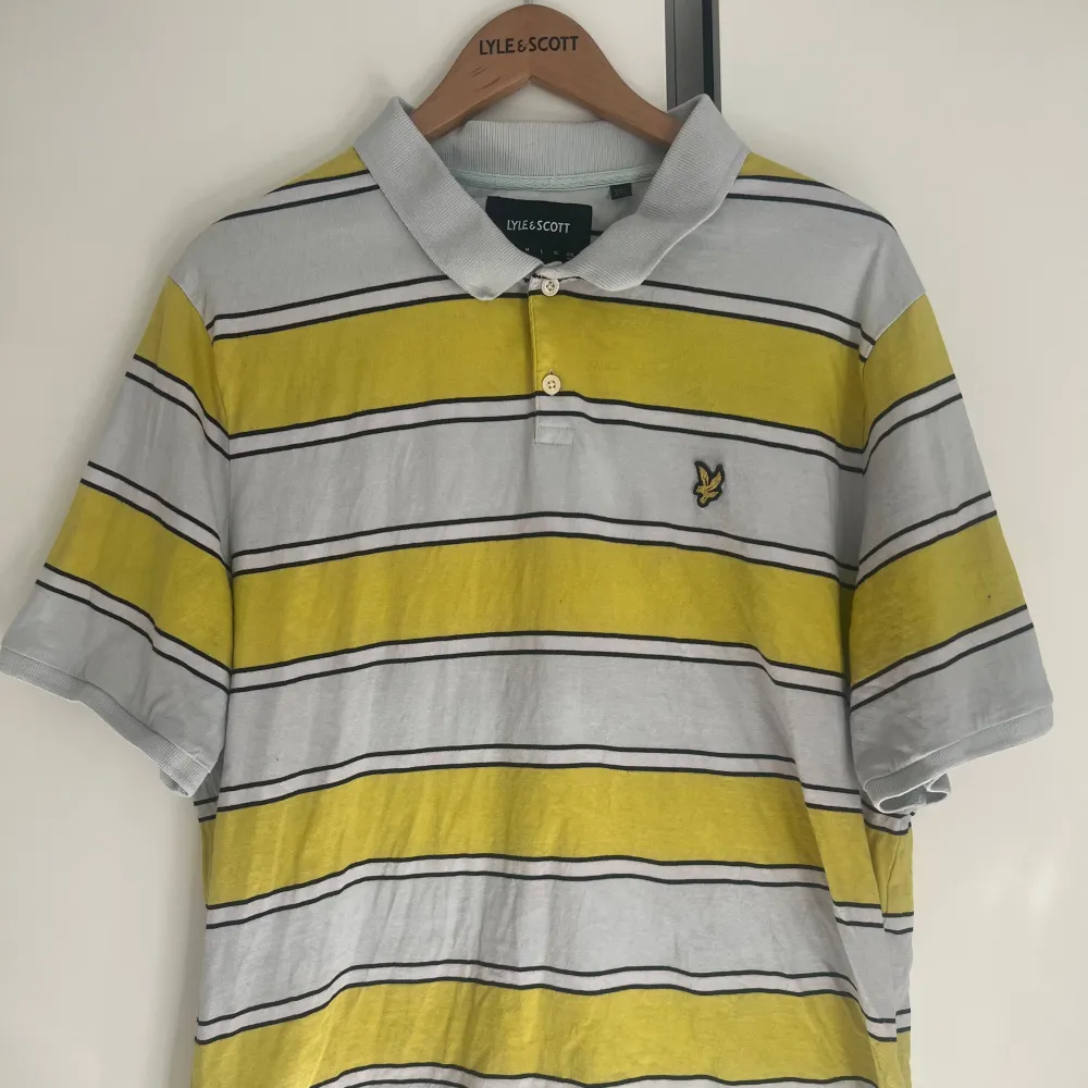 Säljer en snygg och avslappnad pikétröja från Lyle & Scott i storlek xxl. Tröjan har ett fräscht randigt mönster. Den har korta ärmar och en klassisk krage med knappar. Perfekt för sommardagar eller en avslappnad stil.. Tröjor & Koftor.