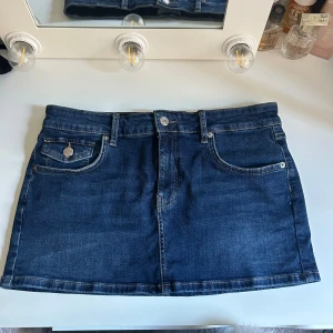 Mini jeanskjol - Supersnygg lågmidjad mini jeanskjol som tyvärr inte blivit använd❤️‍🔥 Materialet gör att storleken fungerar +/- en strl. Jag brukar bära strl 38 i jeans.