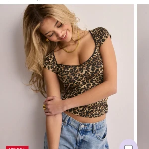 Leopardmönstrad topp - Trendig leopardmönstrad topp med korta ärmar och en figurnära passform. Perfekt för att ge en djärv touch till din outfit. Andvänd en gång. 