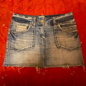 Kort jeanskjol - Fin kort jeanskjol med söta små detaljer på fickorna (och minifickorna), perfekt till alla lookar oavsett väder. Sitter lågmidjad/mid waist 