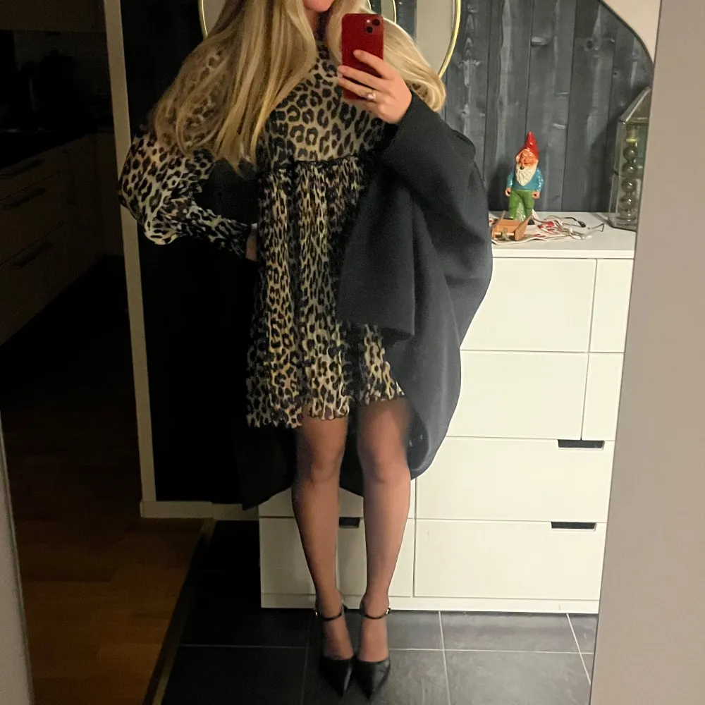 Trendig leopardmönstrad klänning med lång ärm och luftig passform. Klänningen har en kort längd och är från märket Ganni. . Mekot.