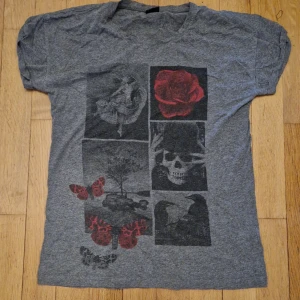 Grå t-shirt med tryck från Gina Tricot - Grå T-shirt från Gina Tricot i strl M. Tryck med ros, dödskalle, fjäril, ballerina mm. Katt i hemmet. 