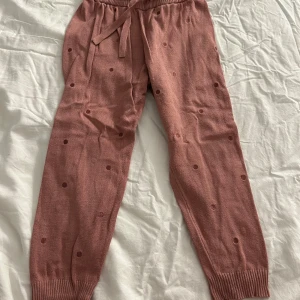 Rosa mjukisbyxor från Pomp de Lux - Säljer ett par söta rosa mjukisbyxor från Pomp de Lux. Byxorna har ett prickigt mönster och ribbade muddar vid bensluten. De är utrustade med en praktisk snörning i midjan för bästa passform. Varan kommer att tvättas och strykas innan leverans! ⭐️