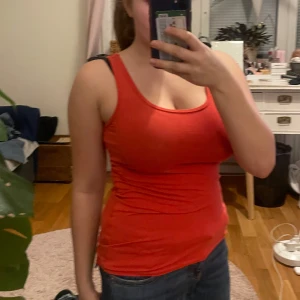 Röd linnetopp från Sunshine - Snygg röd linnetopp från Sunshine. Perfekt för varma dagar med sin ärmlösa design och bekväma passform. Enkelt att matcha med jeans eller shorts för en avslappnad look.