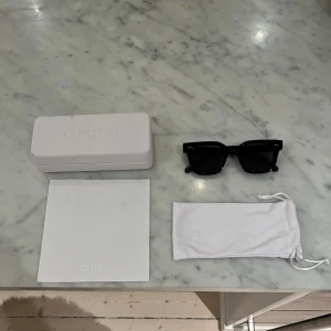 Svarta Chimi 04 - Säljer ett par snygga svarta chimis som passar till allt. Har använt dem ungefär 3 gånger och de är så gott som nya. Priset går att diskutera. De kommer med originalförpackning och en vit förvaringspåse. Perfekta för soliga dagar!