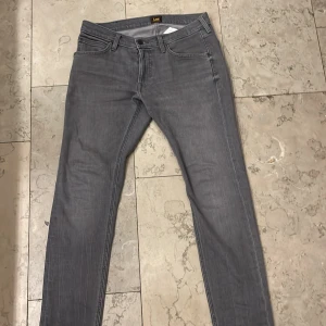 Grå lee jeans slim fit  - Jättesnygga jeans från lee i storlek 30/30. Trendiga modellen ”Luke” och jeansen är i så gott som nyskick. Ingen defekt. Säljer endast då de är för små för mig, annars hade jag behållt. Köpta från nlyman för en tusenlapp🙏🏽 