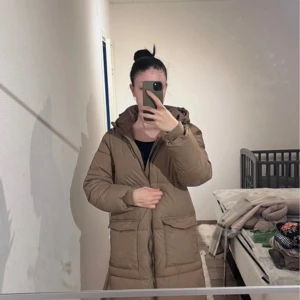 Beige dunjacka från Object - Säljer en beige dunjacka från Object i storlek S. Jackan har en dragkedja framtill och långa ärmar. Perfekt för kyligare dagar med sin pufferdesign som håller dig varm och bekväm.