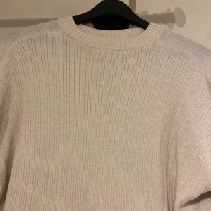 Beige ribbad tröja - En jättefin ljus beige ribbad tröja i bra skick, som endast har använts ett fåtal gånger. Den har slitsar på sidorna och vid armarna. Tröjan är medellång och har en något oversized passform. Lite tunn, men väldigt skön. Skriv vid frågor🤍