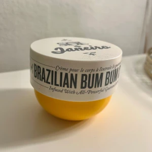 Brazilian Bum Bum Cream - En lyxig kroppskräm från Sol de Janeiro, känd som Brazilian Bum Bum Cream. Den kommer i en rund gul burk med vitt lock och är berikad med guaraná-extrakt för att strama upp och återfukta huden. Ca hälften kvar.