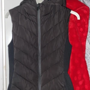 Svart dunväst från Zara - Snygg svart dunväst från Zara med dragkedja och huva. Perfekt för kyligare dagar och enkel att matcha med olika outfits. Använd ca 3 gånger