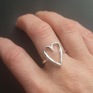Silverring  925 med hjärtdesign - Elegant  helt ny silverring  925 med en öppen hjärtdesign. Perfekt för att lägga till en subtil romantisk touch till din stil. Ringen har en slät yta och är lätt att bära varje dag.