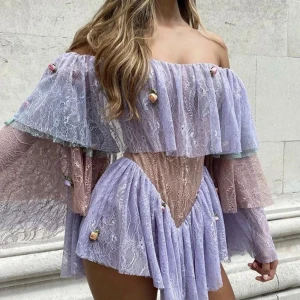 Lila spetsklänning med volanger - Charmig offshoulder klänning i lila spets från det stora märket: thedollhousefashion som syns i stora tidningar som vouge och eller magazinr. Klänningen har volanger och dekorativa blommor. Klänningen har långa ärmar och en kort längd, perfekt för festligheter. Ordpris: 5000