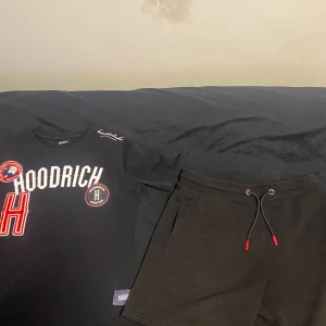 Hoodrich tröja+byxor - Snygg svart t-shirt från Hoodrich med tryck i vitt och rött.Perfekt för en avslappnad stil. Säljs pågrund av att de inte är min stil längre, tröjan är XS och byxorna S. Ända som inte är i nytt skick är snörerna på byxorna, de e lite skrapade, kan skicka bild privat. Pris kan diskuteras.