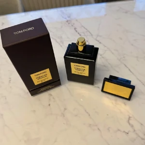 Tom Ford Tobacco Vanille Parfym - Kom med bud!!                          Elegant parfym från Tom Ford i en stilren svart flaska med gulddetaljer. Doften Tobacco Vanille kombinerar rika och kryddiga noter av tobak och vanilj, perfekt för den som söker en sofistikerad och varm doftupplevelse. 95ml kvar av 100ml