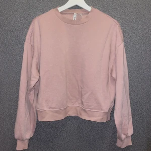 Rosa sweatshirt från H&M Divided - Säljer en mysig rosa sweatshirt från H&M Divided. Tröjan har en klassisk rund hals och långa ärmar. Materialet är en mjuk blandning av bomull och polyester. Stl s, endast använd enstaka gånger.