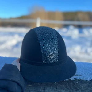 Svart ridhjälm från Charles Owen - Snygg svart ridhjälm från Charles Owen med glittrig detalj på ovansidan. Stl 58, fint skick inte fått någon allvarlig smäll.
