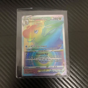 Dragonite VSTAR Pokémonkort - Säljer ett Dragonite VSTAR Pokémonkort med holografisk yta. Kortet har 280 HP och inkluderar attacker som Giga Impact och Draconic Star. Perfekt för samlare eller spelare som vill förstärka sin kortlek.