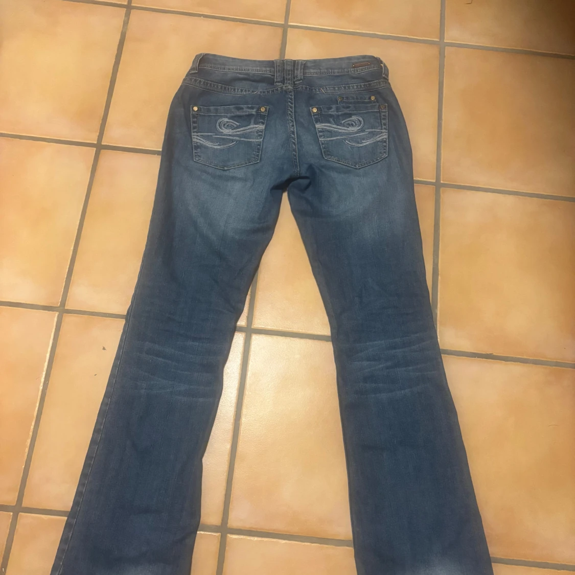 Blå jeans med tryck på bakfickan - 1