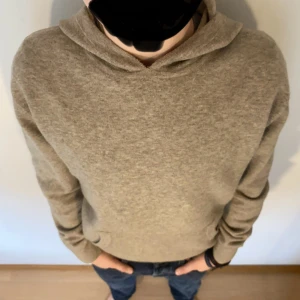 Beige 100% wool hoodie XS/S - Säljer en stilren beige 100% wool hoodie. Den har en klassisk design med en bekväm huva och en praktisk magficka. Perfekt för en avslappnad look. Passar bra till jeans eller joggers.