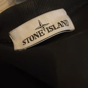 Svart långärmad tröja från Stone Island - Säljer en svart långärmad tröja från Stone Island. Den är i nästan nyskick förutom att det är ett litet hål vid vänstra armbågen. Det går enkelt att sy ihop dock.