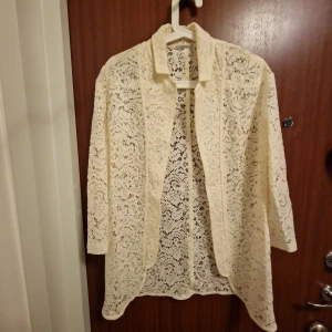 Spetsblus - Spetsblus intimismi  i genombruten kvalitet. Rak modell med ledig skärning som har liten skjortkrage .