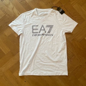Vit t-shirt från Emporio Armani - vit t-shirt från Emporio Armani med EA7-logga på bröstet. (Fick den som en present, har aldrig använt den.)