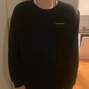 Svart tröja från Peak Performance - Säljer en stilren svart tröja från Peak Performance. Tröjan har en enkel design med rund hals och långa ärmar. Perfekt för en avslappnad look. Hör av er vid funderingar!