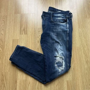 Blå jeans från Replay - Ett par Replay anbass Hyperflex, ganska slitet skick 7/10, storleken är 32/32, finns lite defekter på baksidan av vänsterben, hör av dig vid frågor och funderingar