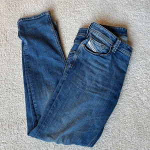 Blå Diesel jeans - Snygga blå jeans från Diesel med diskret logga på myntfickan. Perfekta för en avslappnad stil med en straight passform. Mycket bra skick. Storlek 31/32. 