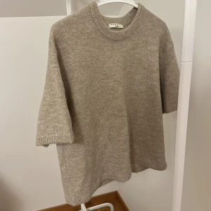 Beige stickad tröja från Gina Tricot - Säljer en stilren beige stickad tröja från Gina Tricot i premiumkvalitet. Tröjan har en rund halsringning och trekvartsärmar, perfekt för en avslappnad look. Passar utmärkt till både jeans och kjol. 🧶