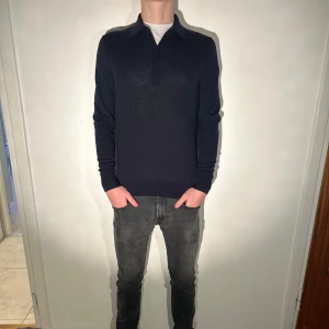 Stickad pikétröja Uniqlo - Mörkblå stickad pikétröja med en krage av tre knappar. Hör av dig vid funderingar!