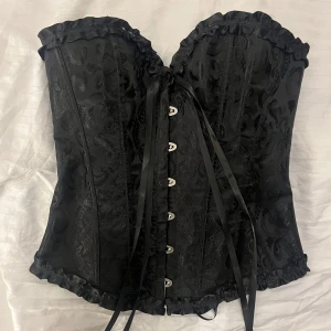Svart korsett med spetsdetaljer och snörning  - Svart korsett med mycket detaljer med ställbar snörning bak och knyte fram. Inte köpt från shein! Märke går att lösa om det skulle va intressant. Storlek S. Endast testad på. Köpte för 300 säljer för 130 frakt ingår. 