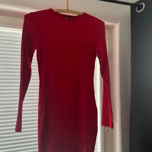 Röd ribbad klänning från FB Sister - Snygg röd ribbad klänning från FB Sister i storlek XS. Klänningen har en tight passform och långa ärmar, perfekt för en stilren look. Den är enkel men ändå elegant, vilket gör den till ett mångsidigt plagg i garderoben.