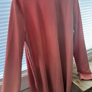 Rosa långärmad klänning från Gina Tricot - Säljer en snygg rosa långärmad klänning från Gina Tricot. Perfekt för en avslappnad stil. Klänningen har en mjuk och bekväm känsla.