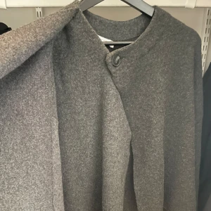Grå kofta från zara - Supermysig kofta från zara med knäppning upptill samt att man kan dra igenom så det blir som en halsduk. Skriv för mer bilder! Stl S-M💌