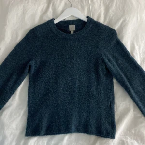 Mörkgrön stickad tröja - Mysig grå stickad tröja med rund halsringning och långa ärmar. Perfekt för kyliga dagar och enkel att matcha med olika outfits.