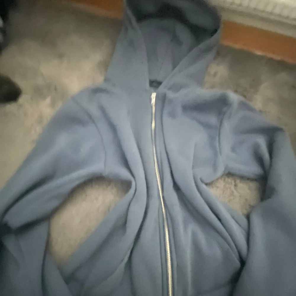 Säljer en mysig blå hoodie från 157 i storlek M. Den har en praktisk dragkedja framtill och en skön huva. Perfekt för kyliga dagar eller som ett extra lager. Använd men i bra skick!. Tröjor & Koftor.