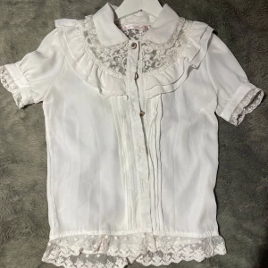 Vit lolita blus - En söt och elegant vit blus med spets detaljer och guldiga knappar.  