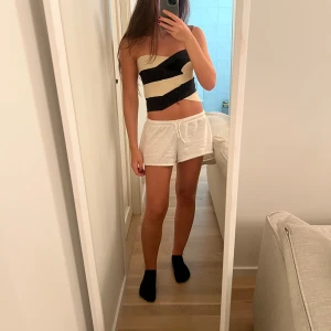 Randig tubtopp - Snygg randig tubtopp i svart och vit. Perfekt för sommardagar eller en utekväll. Toppen är croppad och har en tight passform. Den är ärmlös och ger en cool och avslappnad look.