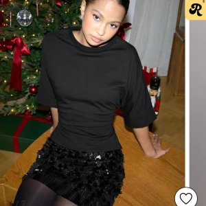 Svart kortärmad topp med knyt - Snygg svart topp med korta ärmar och knytning i ryggen. Perfekt för en stilren look till både vardag och fest. Toppen har en croppad passform som ger en modern touch.