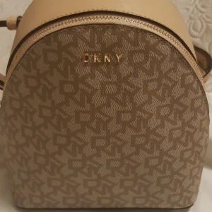 Väskor  - Jag säljer min fina Rygväska DKNY mycket bra skick använd 2gånger Inga skador ej smutsig,,,men stått i garderoben ett bra tag,,,,,Hör av dig vid intresse,,,,,,,,,,