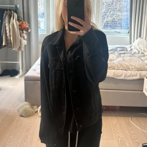 Svart jeansjacka H&M - Säljer en svart jeansjacka i mycket bra skick. Den har en klassisk design med knappar framtill och långa ärmar. Jackan har en normal passform och är superlätt att matcha med olika outfits. Storlek S, over sized passform