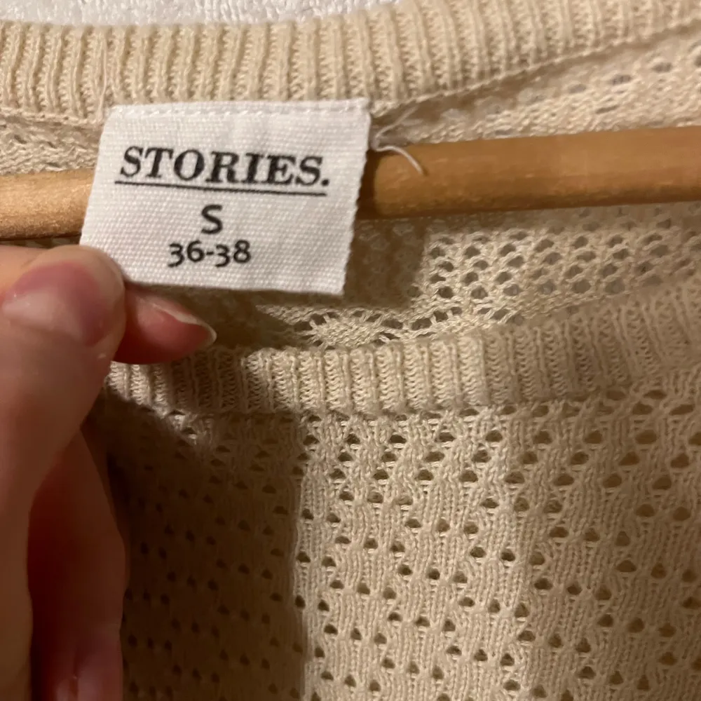 Beige finstickad tröja med volanger och mönster från Stories i storlek 36/38 S, fint skick.. Stickat.