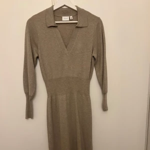 Beige klänning från Vila - Säljer en superfin beige klänning från Vila i merinoull och nylon. Den har en v-ringad design med trekvartsärmar, perfekt för höst och vår. Klänningen är i mycket bra skick och passar både till vardags och festligare tillfällen. Väl omhändertagen 