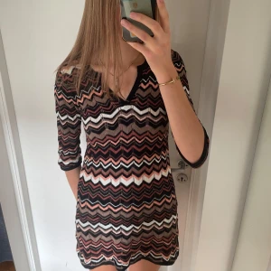 Missoni liknande klänning - Missoni liknande kort klänning! Så himla fin, som passar till allt! 3/4 långa ärmar  Kolla gärna min profil, säljer fler klänningar! Storlek xs men passar xs-m då den är stretchig:)