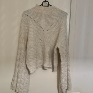 Stickad tröja  - Stickad tröja med utsvängda aramar.