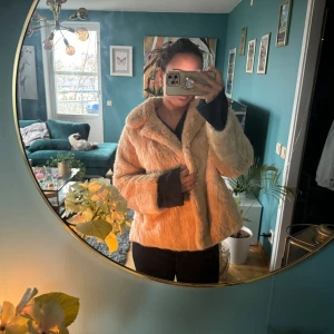 Beige pälsjacka - Säljer en supermysig beige pälsjacka i mycket bra skick. Den är perfekt för höst och vinter och har långa ärmar. Jackan har en normal passform och stängs med knappar framtill. Den är både stilren och varm, perfekt för kyliga dagar. 🧥✨
