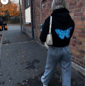 Svart hoodie med blå fjäril - Säljer en svart hoodie med en stor blå fjäril på ryggen, det är även en liten fjäril på framsidan🫶🏼Märket är lite slitet men fortfarande i bra skick. Säljs för 250kr (nypris ca 550)💗Är i M men passar även S